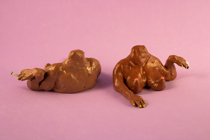 Studio photo of two clay figurines depicting female busts